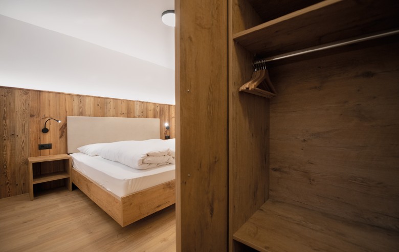 Camera piatta con mobili in legno e comodo letto matrimoniale