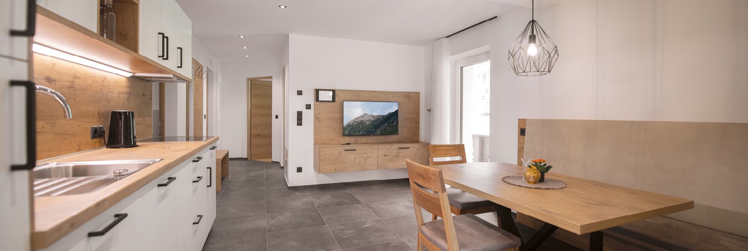 Cucina abitabile completamente attrezzata con moderno angolo cottura, un'invitante zona pranzo