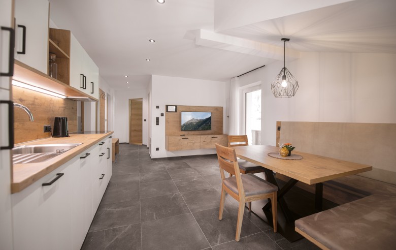 Cucina abitabile completamente attrezzata con moderno angolo cottura, un'invitante zona pranzo