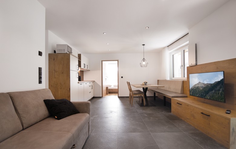 Appartamento per le vacanze appena ristrutturato con divano, TV, zona pranzo e angolo cottura