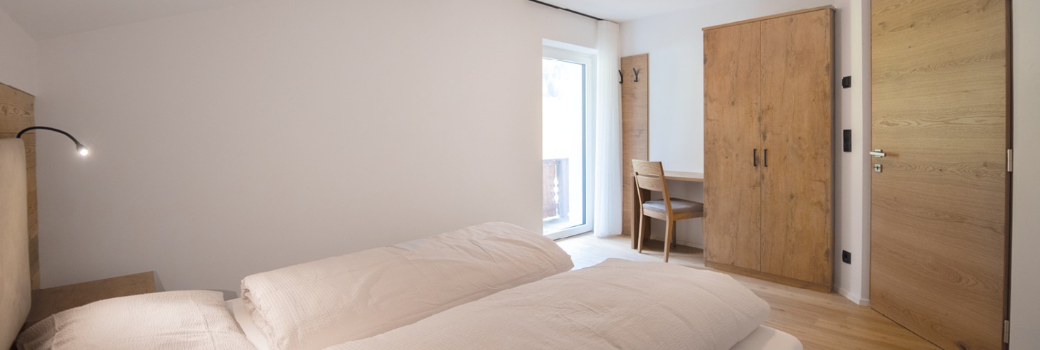 Camera doppia arredata in modo spazioso con armadio e balcone