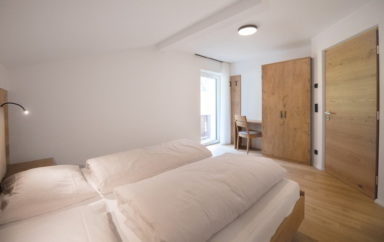 Camera doppia arredata in modo spazioso con armadio e balcone