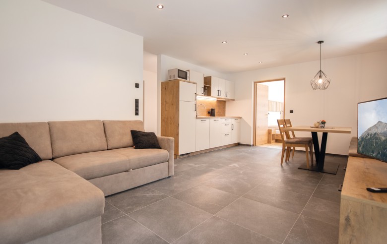 Ampi appartamenti con cucina, zona pranzo, divano e TV