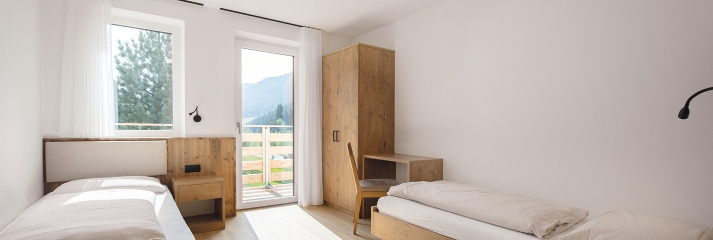 Confortevole camera d'appartamento con letti singoli e balcone con vista sulla natura di Racines