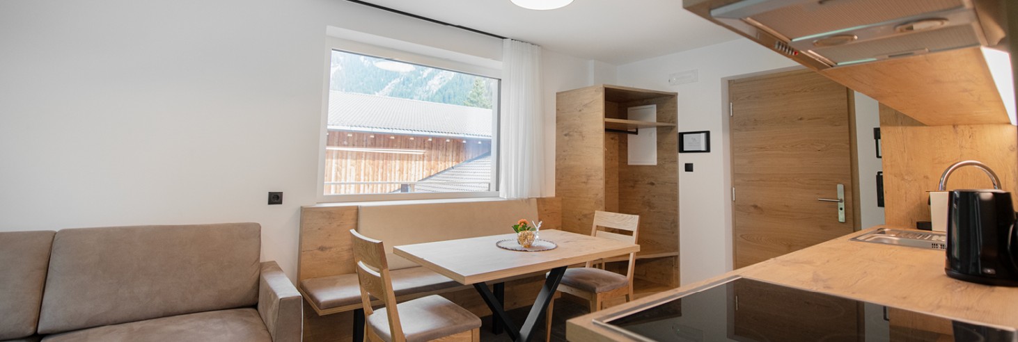 miramor: Accogliente cucina abitabile in un appartamento per vacanze da miramor Invitante cucina abitabile con un accogliente tavolo da pranzo e un comodo divano