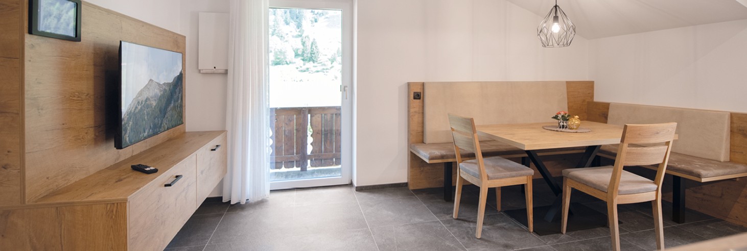 Appartamento con ampia zona giorno, tavolo da pranzo, cucina e balcone