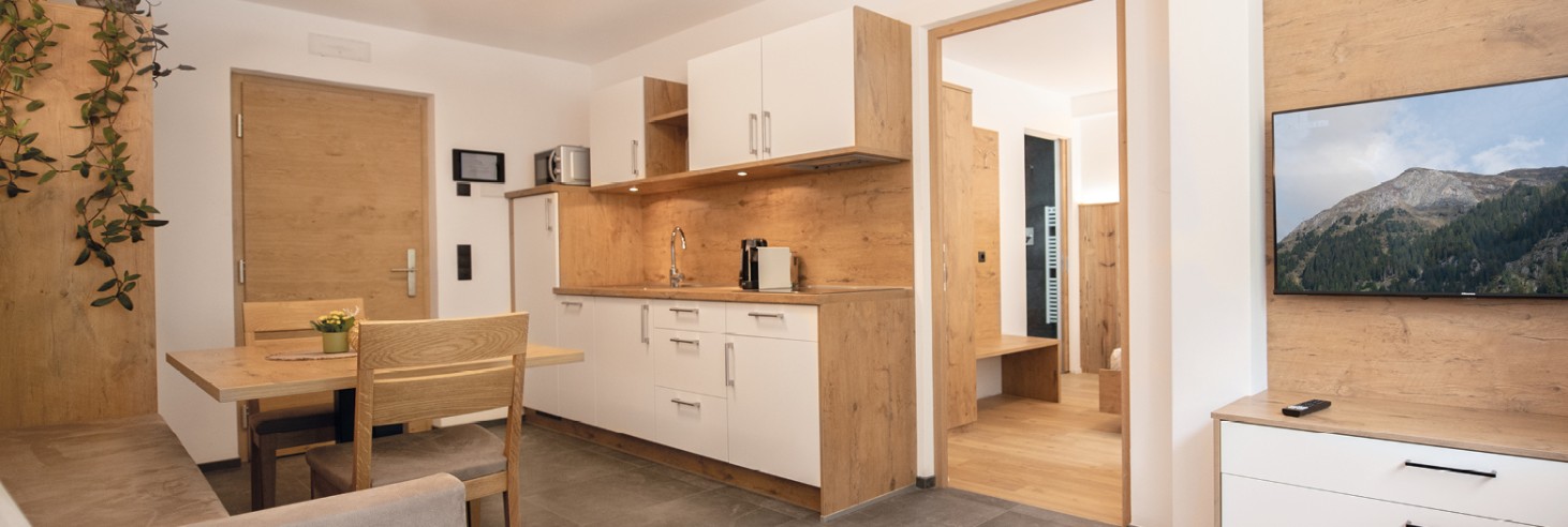 Appartamenti arredati in modo confortevole con angolo cottura, tavolo da pranzo e zona giorno