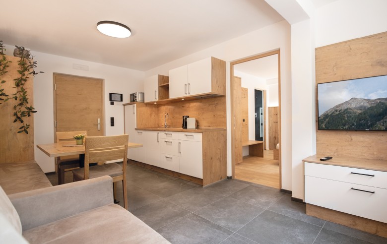 Appartamenti arredati in modo confortevole con angolo cottura, tavolo da pranzo e zona giorno